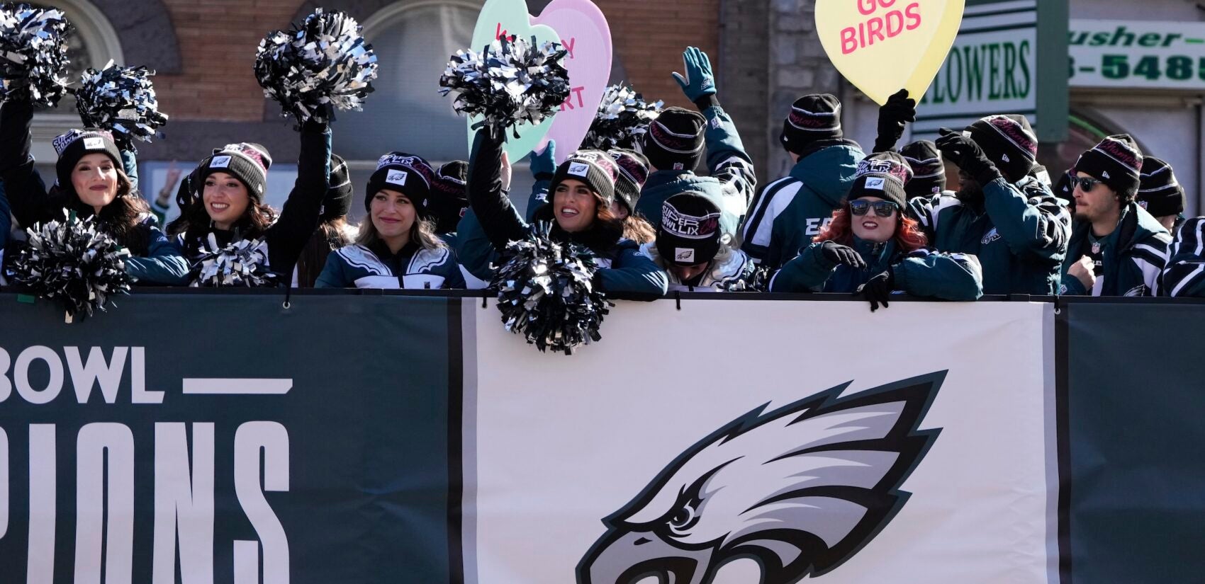 Chearleaders waving to the crowd from the parade truck