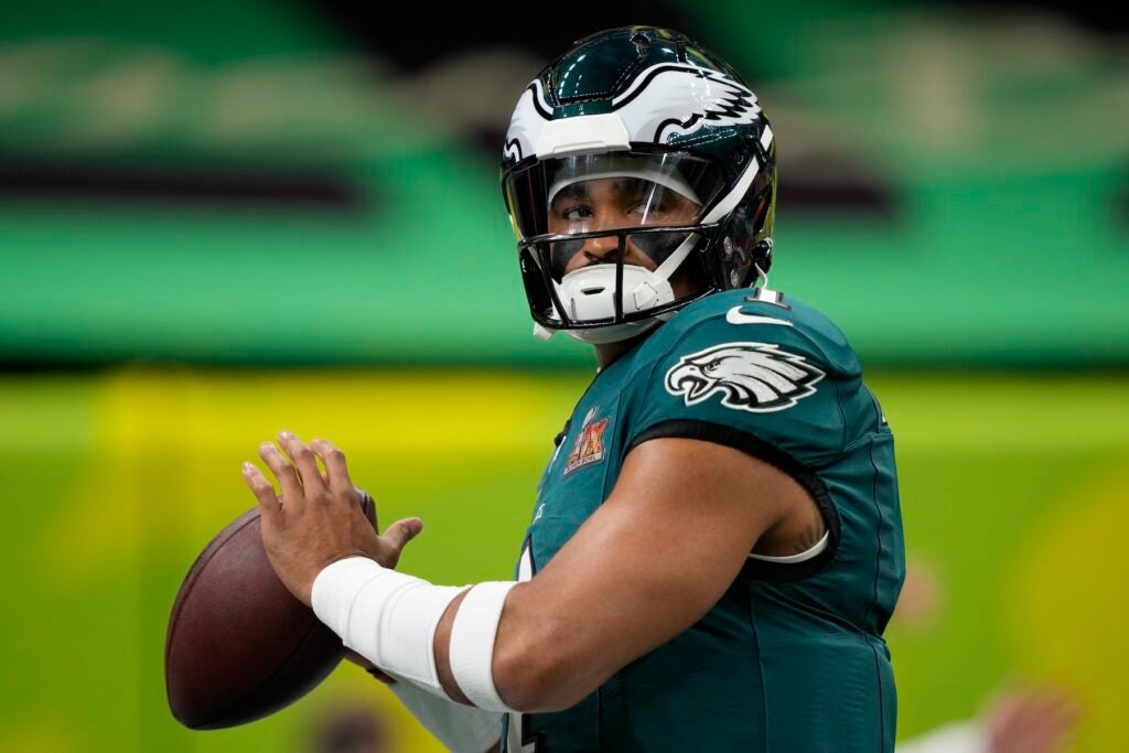 Jalen Hurts getting ready to throw a football while warming up before the game