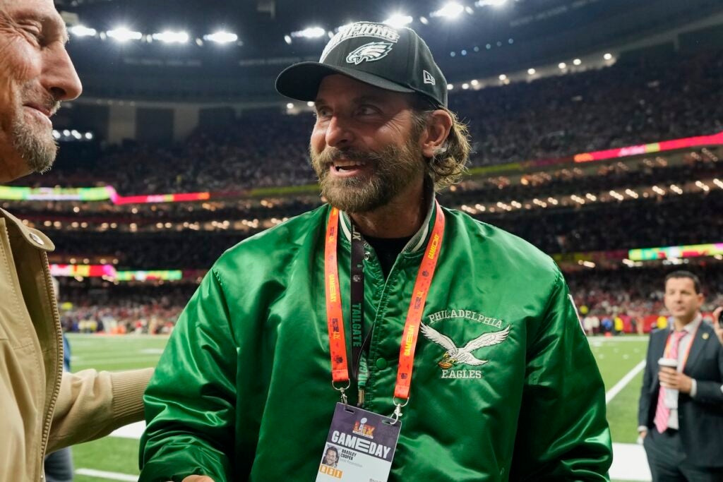 Bradley Cooper wearing an Eagles jacket while on the field before the game