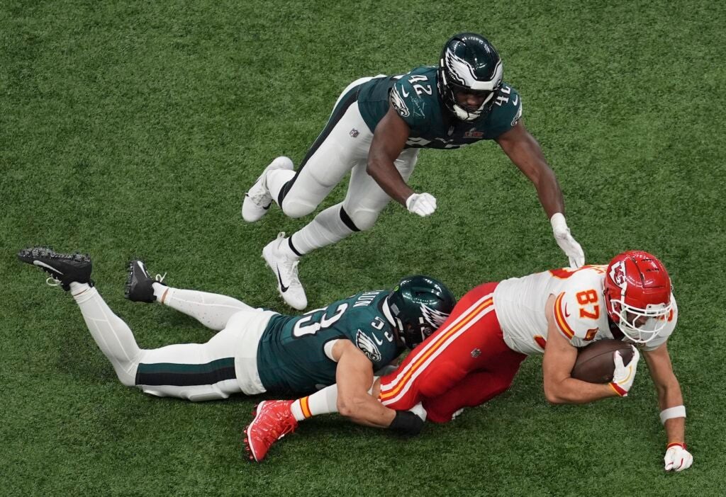 Eagles players tackling a Chiefs player with the ball