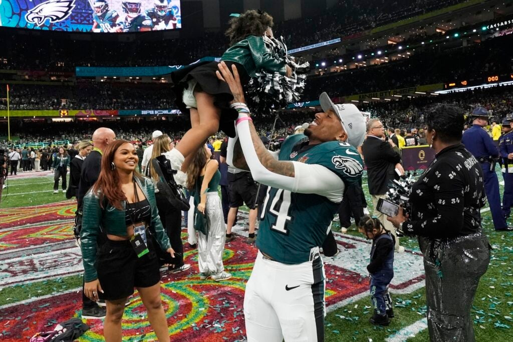 Isaiah Rodgers lifts his young daughter in the air after the game