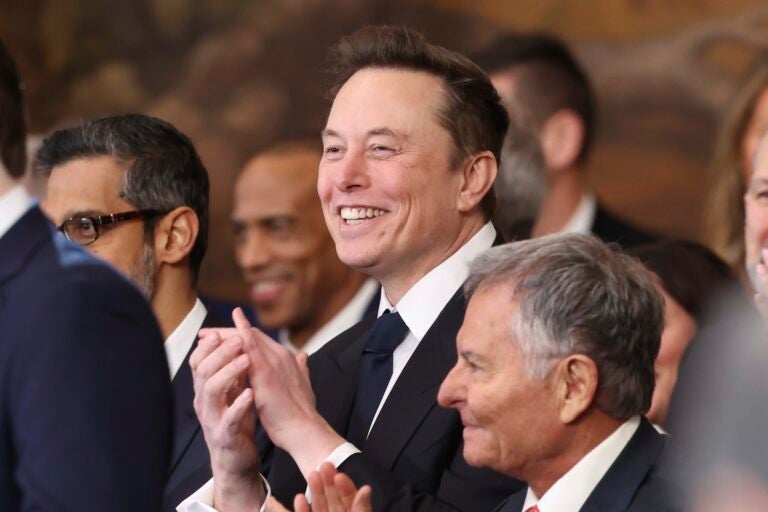 Elon Musk smiling and clapping