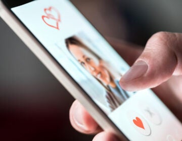 A man is looking at photo of a woman on dating app. (Bigstock/TeroVesalainen)