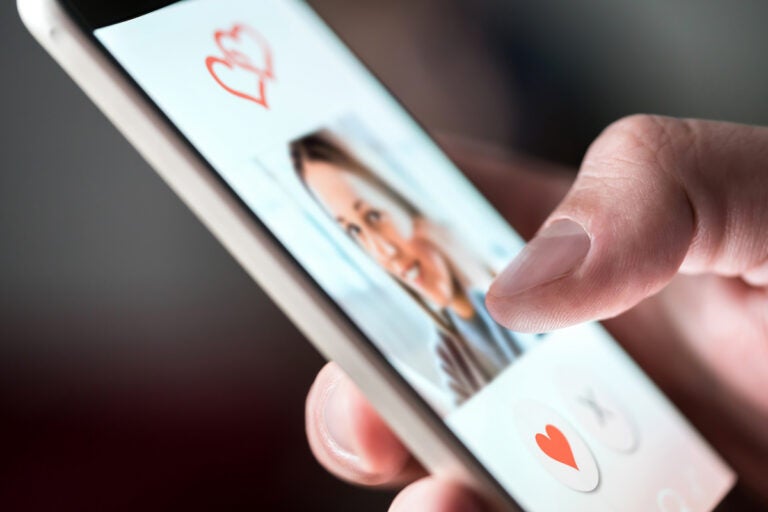 A man is looking at photo of a woman on dating app. (Bigstock/TeroVesalainen)