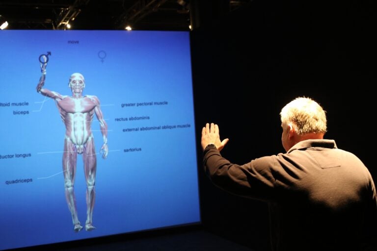 Larry Dubinski raising his hand for an interactive exhibit feature