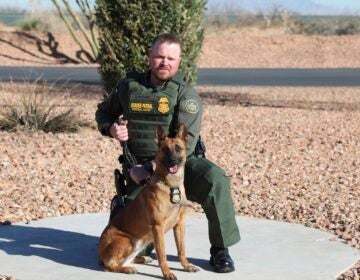 Border Patrol Agent David Maland posing with a service dog