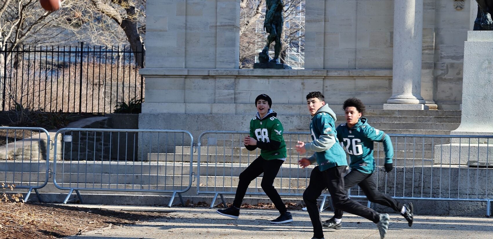 3 boys playing catch with a football