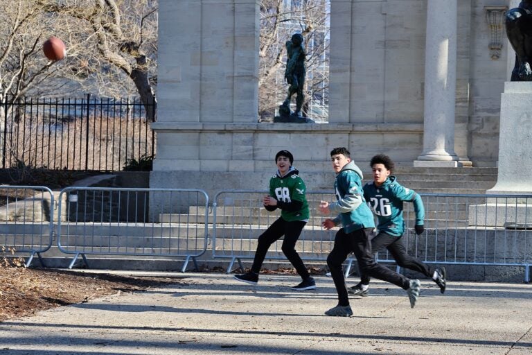 3 boys playing catch with a football