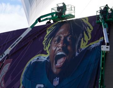 Workers hanging up banners outside the stadium