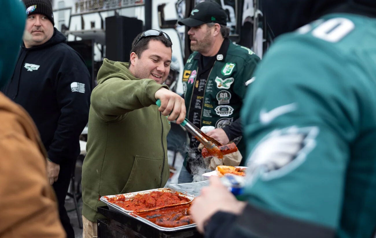 Anthony Byrne serves sausage sandwiches at his uncle Ed Callahan's (not pictured) tailgate