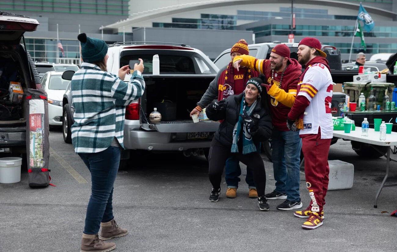 Eagles and Commanders fans are seen at a tailgate