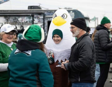 Susan Klabunde (center) dons an eagle costume at a tailgate before the NFC championship game at Lincoln Financial Field in Philadelphia. (Rachel Wisniewski/for NPR)