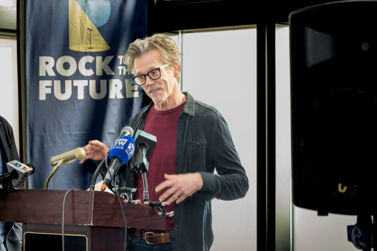 Kevin Bacon speaks at a podium