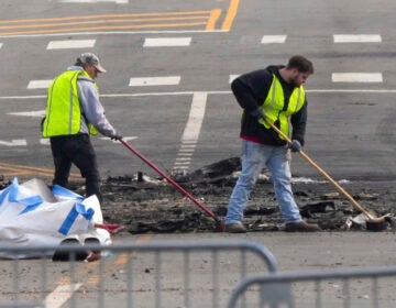 Workers sweeping debris