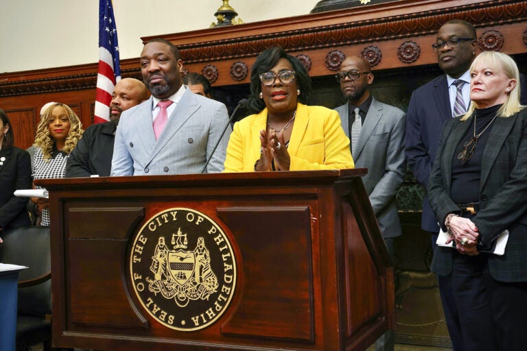 Cherelle Parker speaking at a podium surrounded by other officials