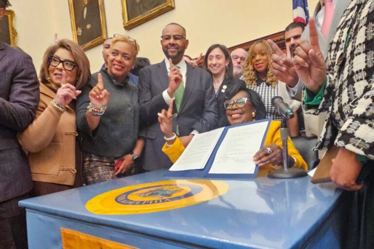 Cherelle Parker sitting at a desk, signing the order