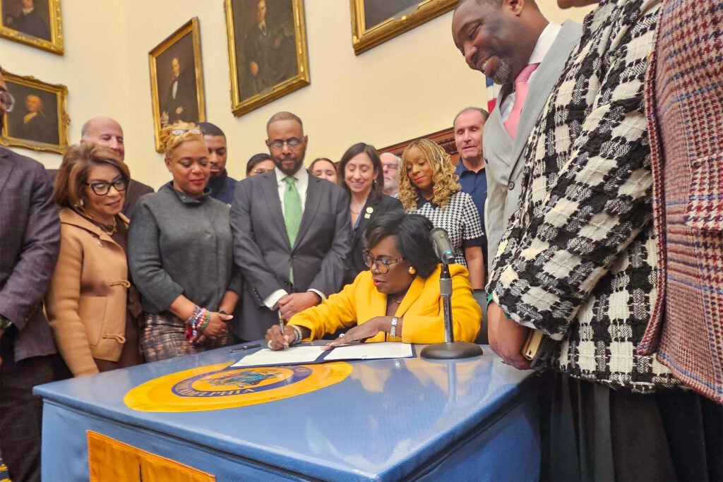 Cherelle Parker sitting at a desk, signing the order