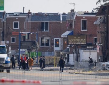 police officers outside damaged structures in the aftermath of a fatal small plane crashed in Philadelphia