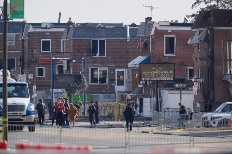 police officers outside damaged structures in the aftermath of a fatal small plane crashed in Philadelphia