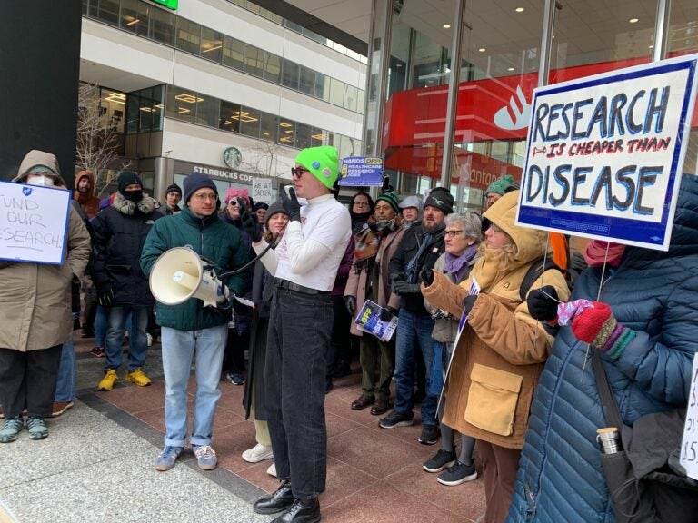 people protesting with a sign reading RESEARCH IS CHEAPER THAN DISEASE