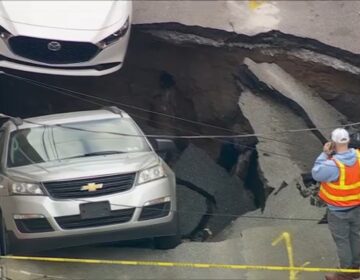 2 cars falling into a sinkhole