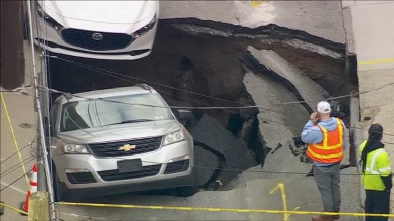 2 cars falling into a sinkhole