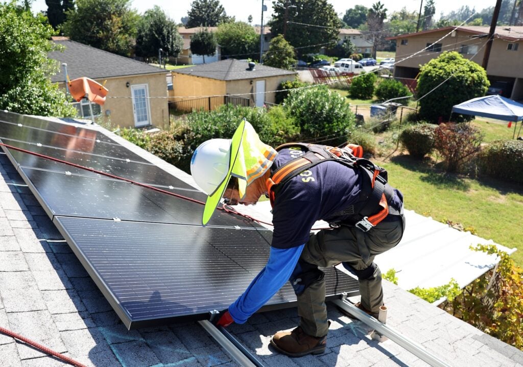 Worker installs no-cost solar panels