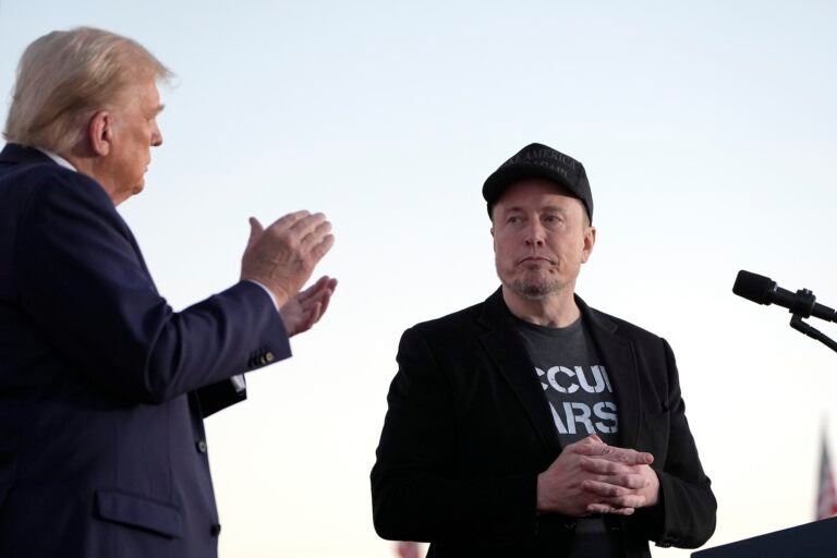 Donald Trump claps next to Elon Musk