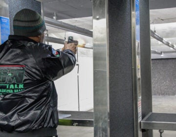 A man aims a gun at a firing range