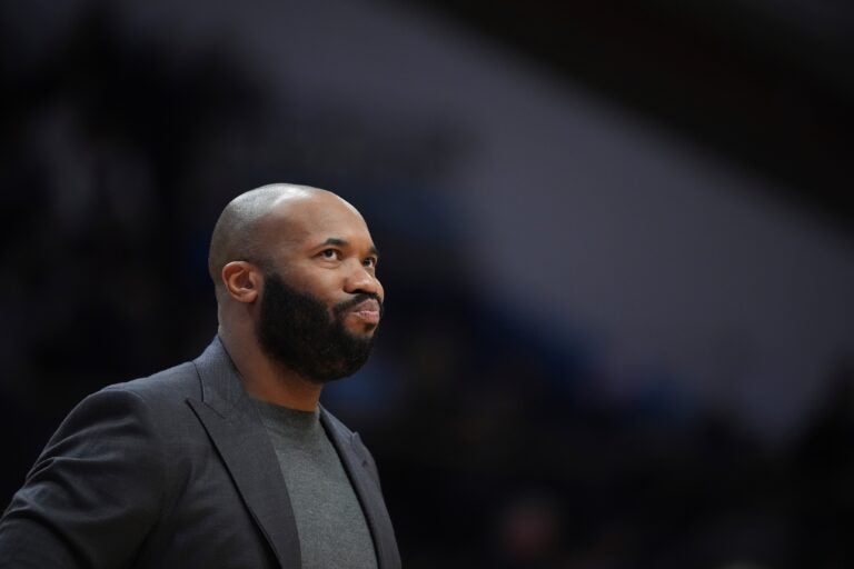 Kyle Neptune watches during an NCAA college basketball game