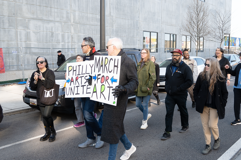 People who work in the Philadelphia culture sector marching with signs reading PHILLY ARTISTS UNITE! and MARCH FOR ART!