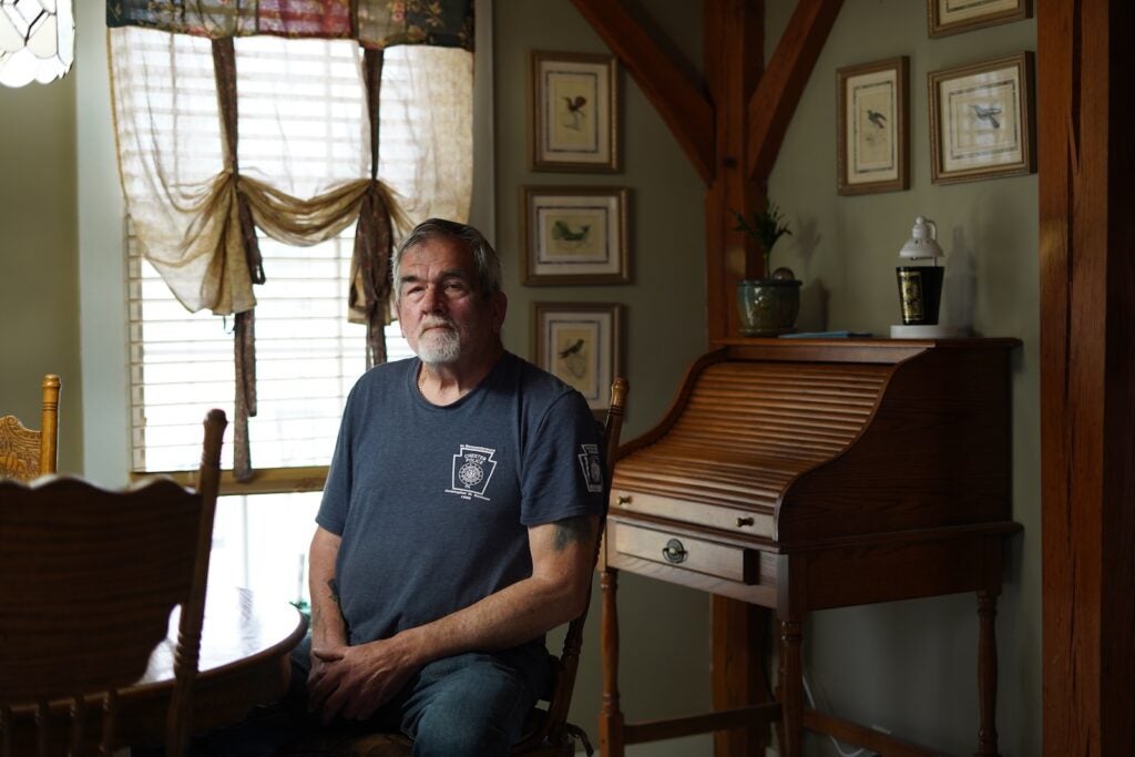 Alan Davis, a retired Chester police captain, sits in his home