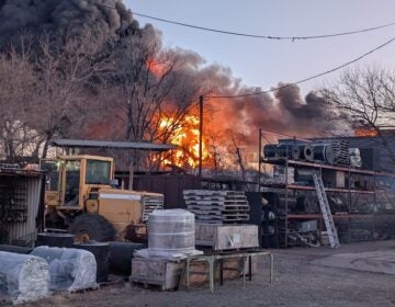 a fire burning at a scrapyard