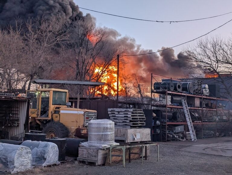 a fire burning at a scrapyard