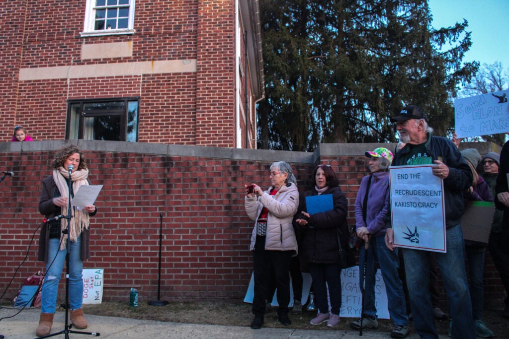 Jessica Tkacs speaks at a Glenside rally decrying federal cuts in the aftermath of the SPS fire on March 4, 2025