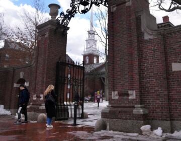 Pedestrians walk through the gates of Harvard Yard at Harvard University