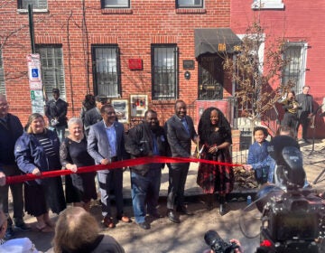 Several dignitaries cut a red ribbon outside the The Marian Anderson Historical Society & Museum in South Philadelphia