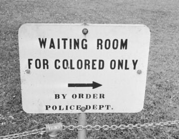 A sign says 'Waiting room for colored only'