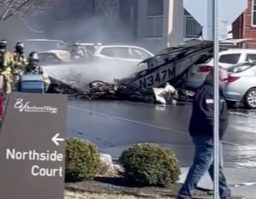 first responders spraying water on a small plane crash