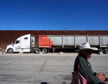 Susano Cordoba, right, sells peanuts to truck drivers