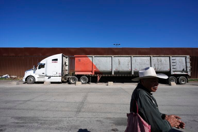 Susano Cordoba, right, sells peanuts to truck drivers