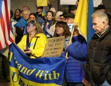 People hold Ukrainian and American flags outside City Hall in Philadelphia