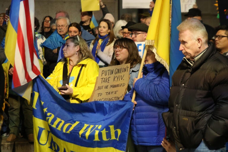 People hold Ukrainian and American flags outside City Hall in Philadelphia