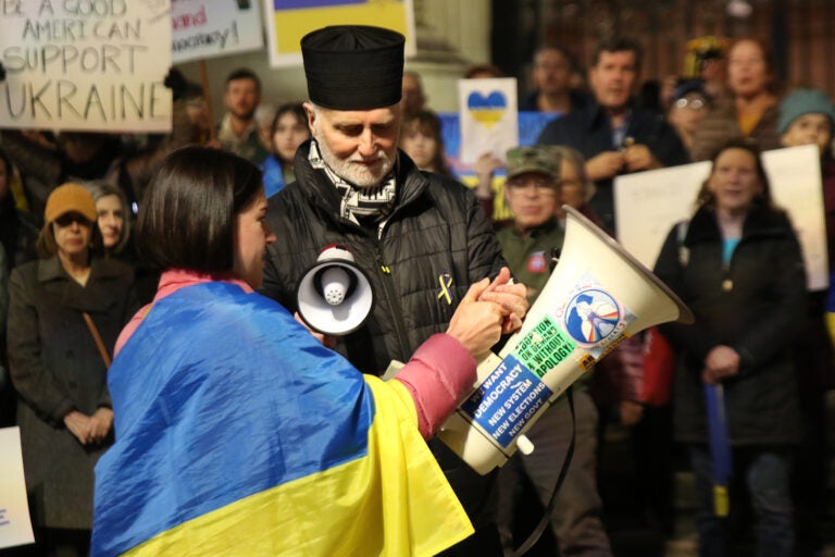 Borys Gudziak received help from an event organizer during Tuesday's protest outside of City Hall