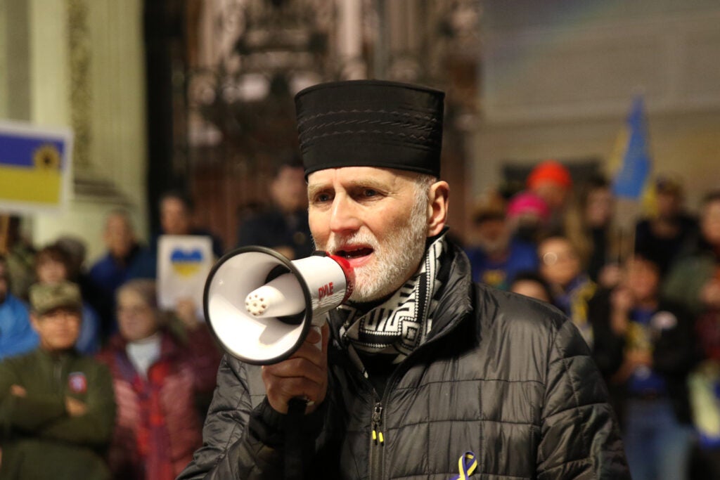 Borys Gudziak, the Metropolitan Archbishop of Philadelphia of the Ukrainian Catholic Church, speaks into a megaphone during a protest outside City Hall in Philadelphia.