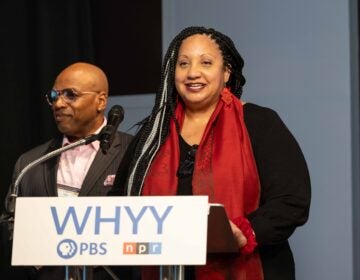 04 04 2025 k paynter civic news summit panel 1_1 Sarah Glover speaking at a podium