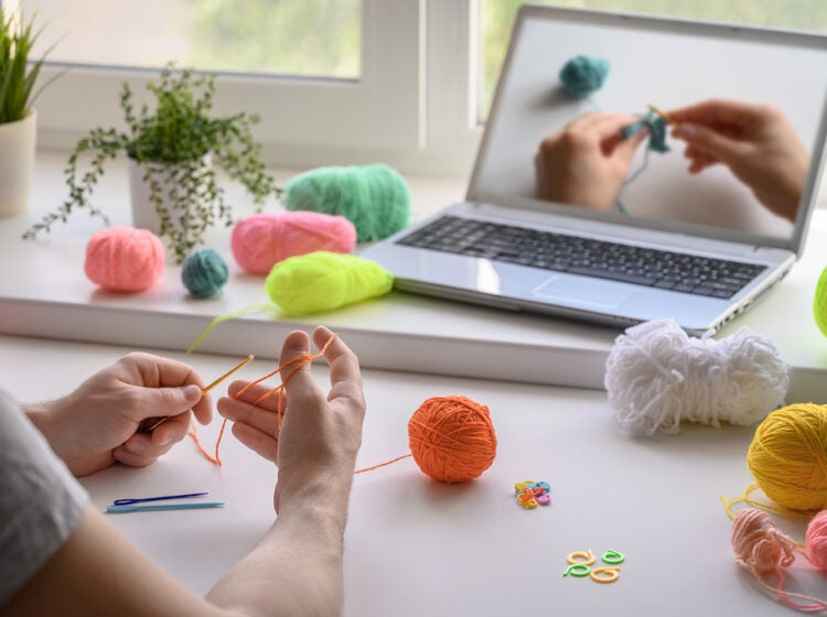 A man is crocheting and watching a tutorial video. (Ramil Gibadullin/Bigstock)