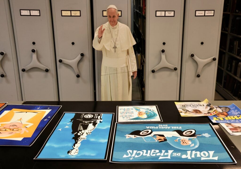 a cutout of Pope Francis and other posters