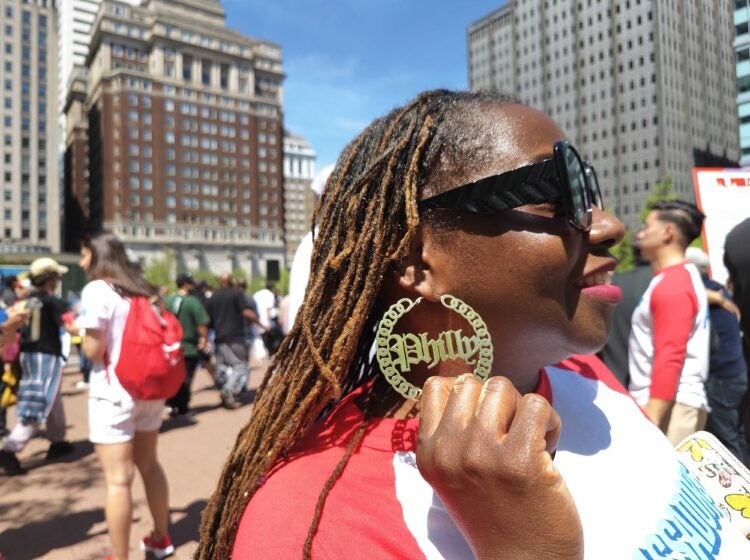 Tiphanie White shows off Philly earrings at the pep rally about volunteering in Philly for the semiquincentennial