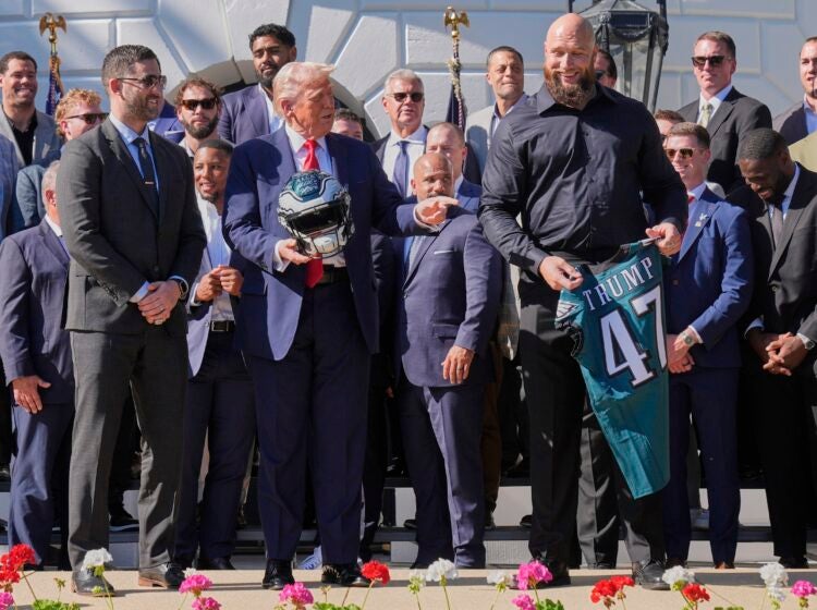 Philadelphia Eagles offensive tackle Lane Johnson, right, and head coach Nick Sirianni, left, President Donald Trump with a helmet and jersey as he welcomes the Super Bowl champion NFL football team to the South Lawn of the White House, Monday, April 28, 2025, in Washington. (AP Photo/Mark Schiefelbein)